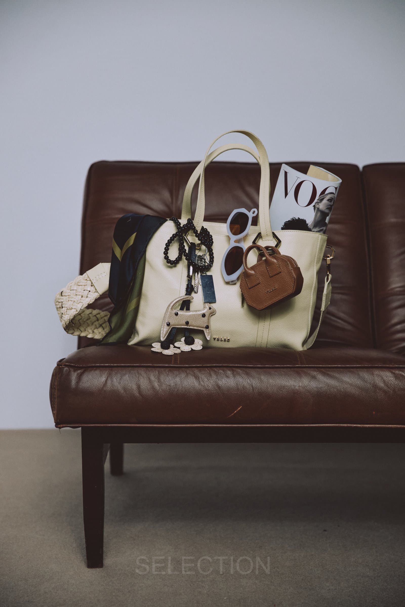 Bolso blanco sobre sofá de cuero
