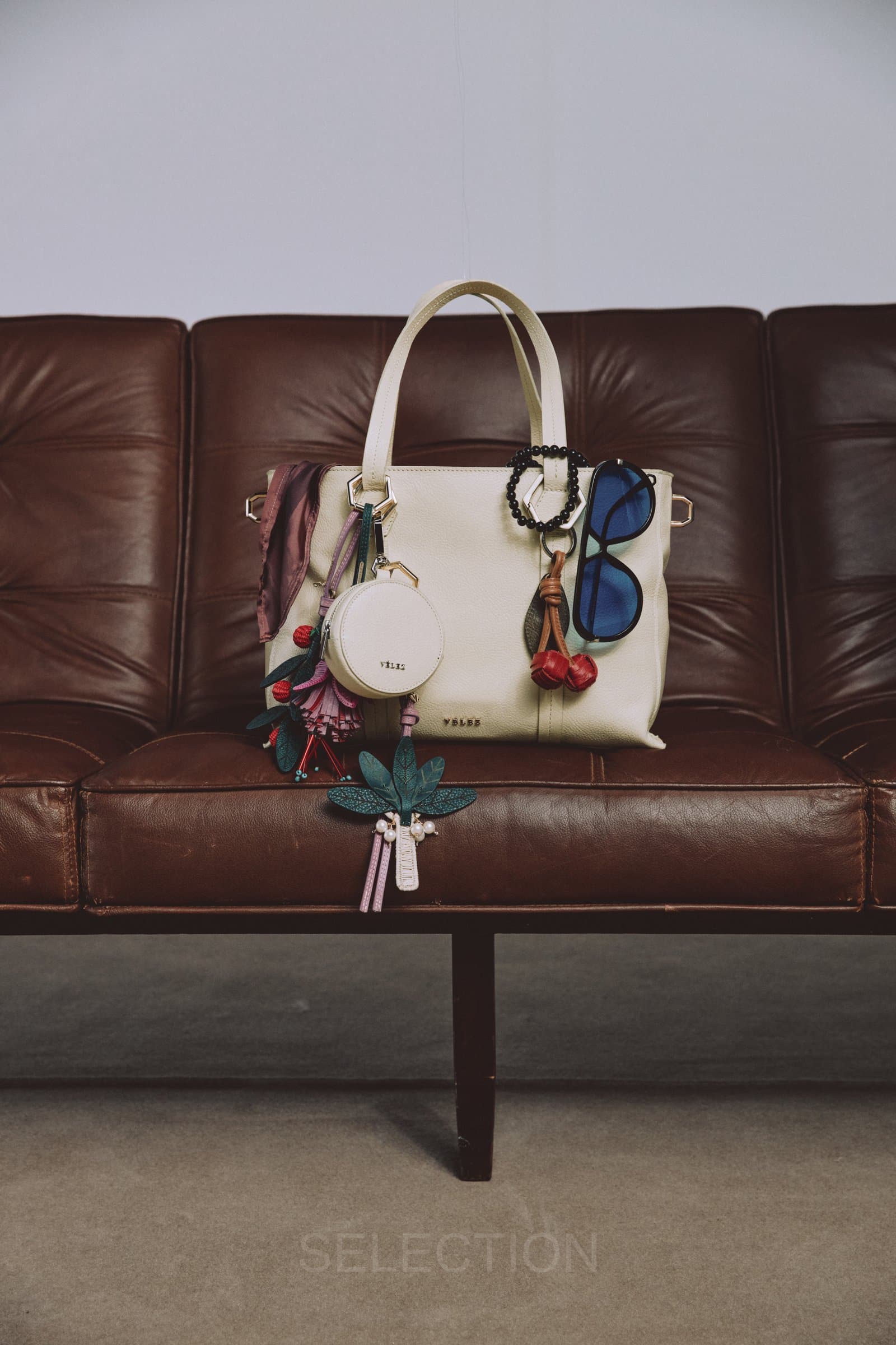Bolso blanco sobre sofá de cuero, otro ángulo